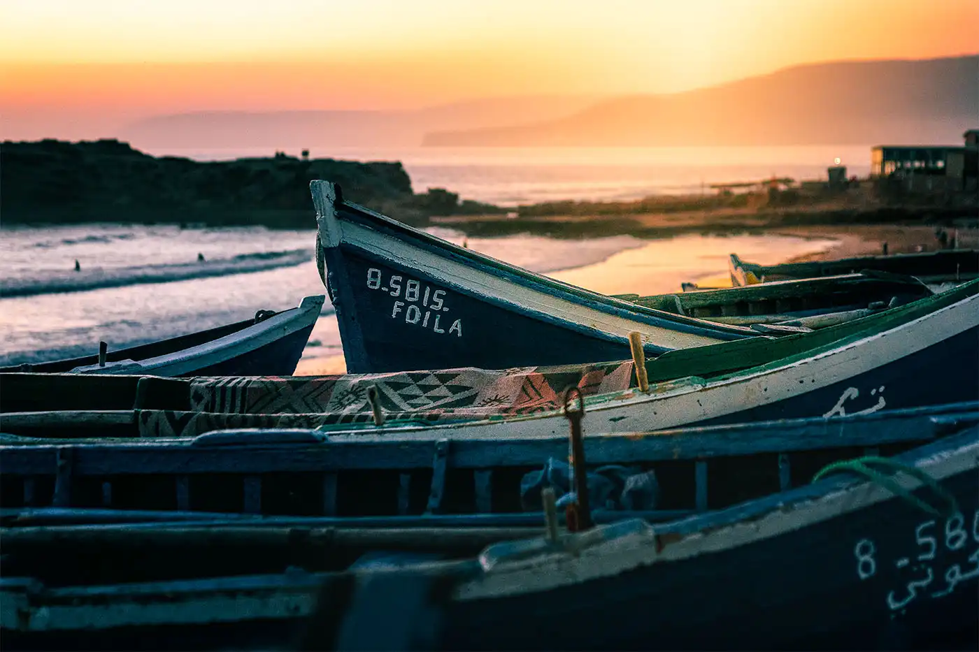 fishing boats with beach in the background